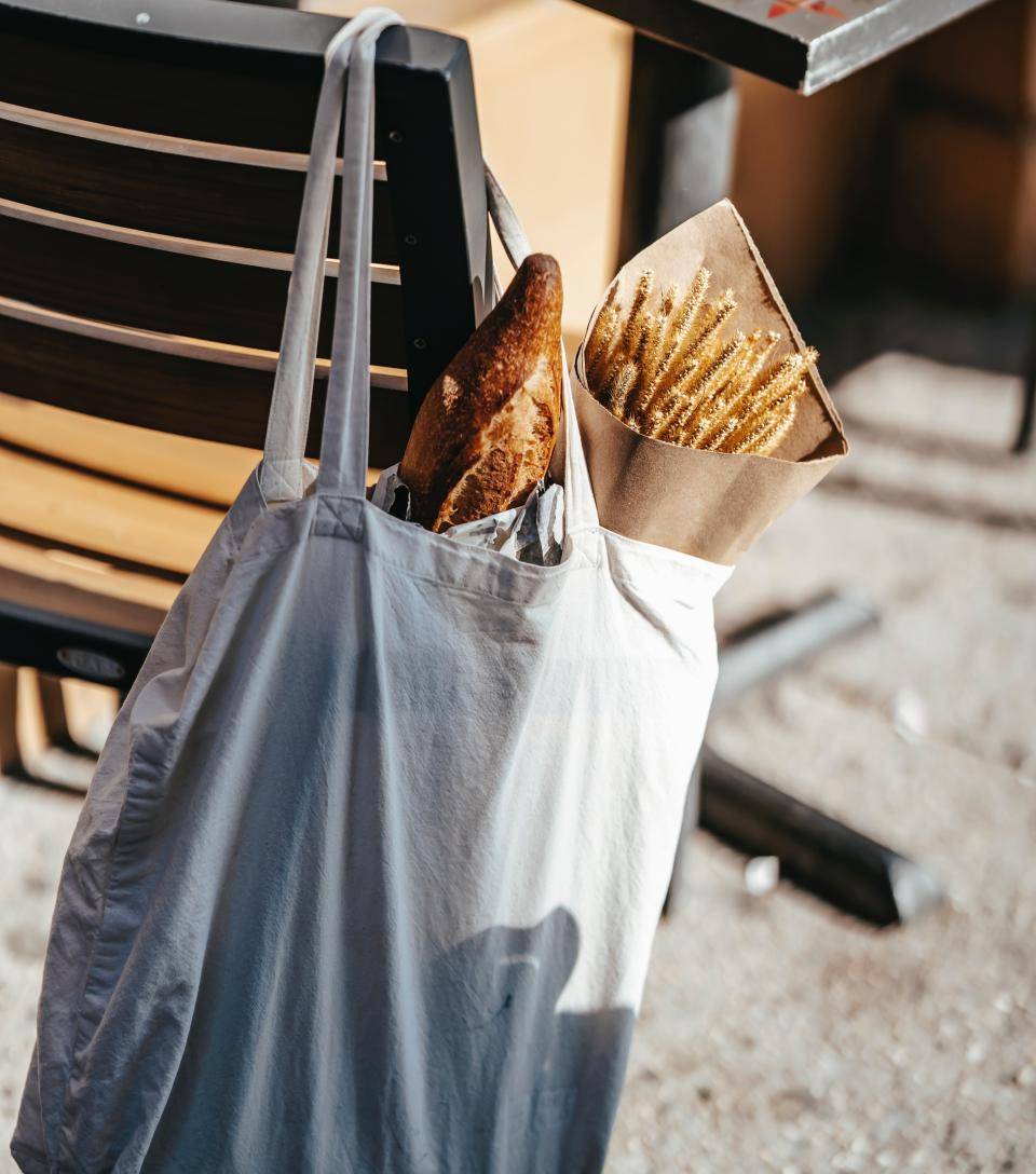 pães dentro de uma sacola pendurados em uma cadeira